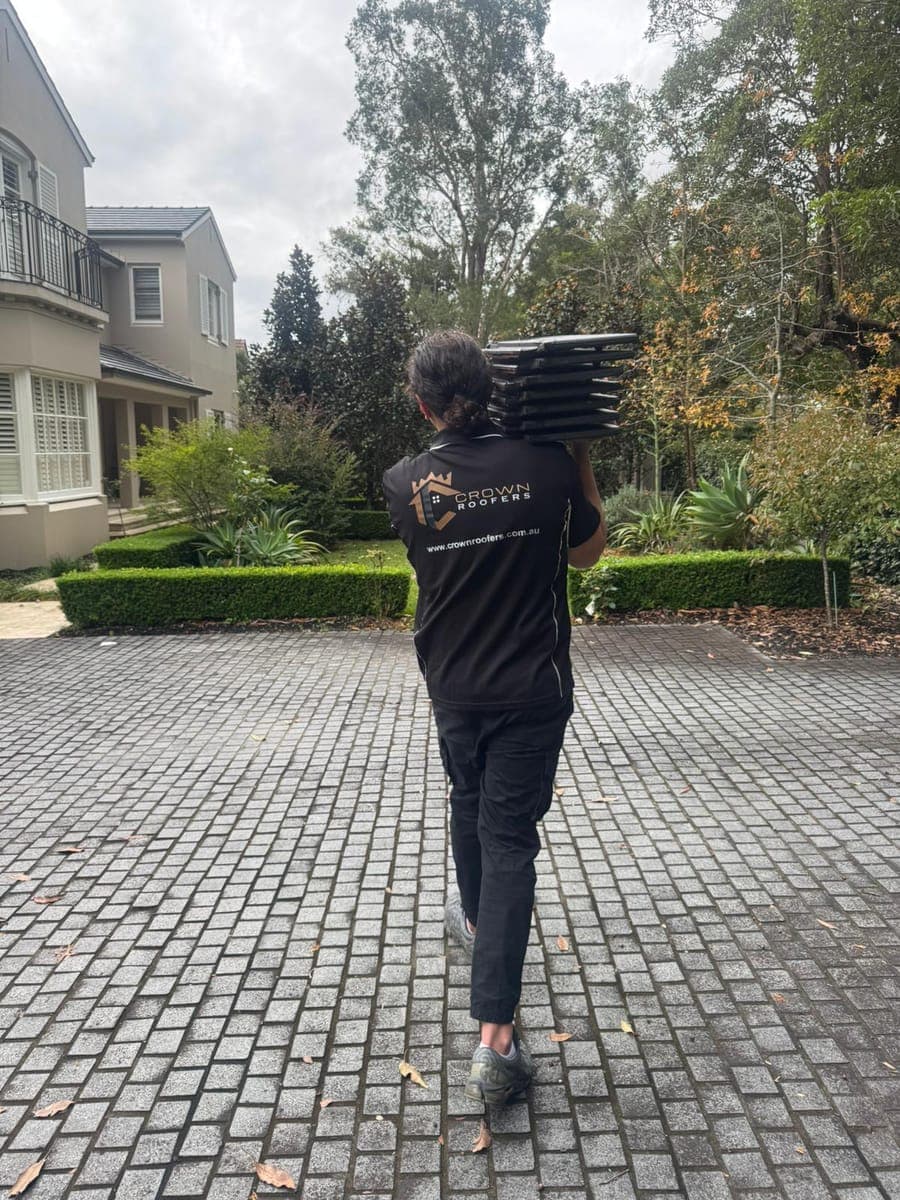 Crown Roofers carrying roof tiles during a Sydney roofing job
