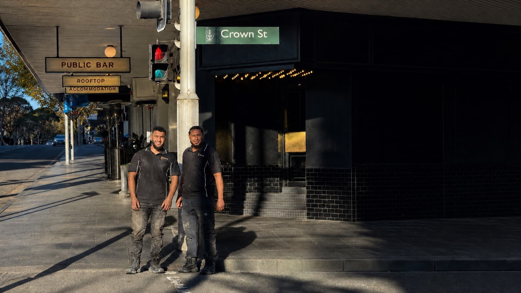 Crown Roofers team beneath the Crown Street sign in Sydney