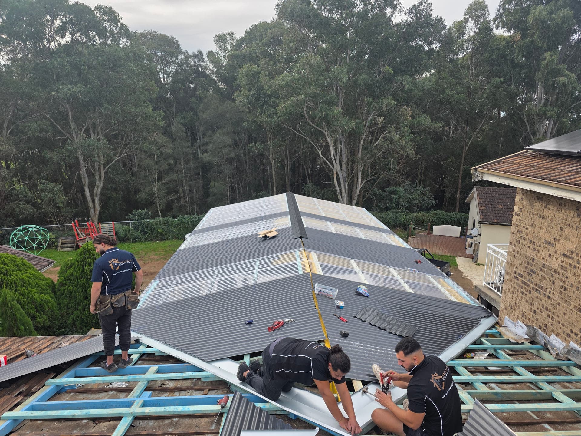 Crown Roofers crew installing a new corrugated metal roof in Bonnyrigg, Sydney NSW.